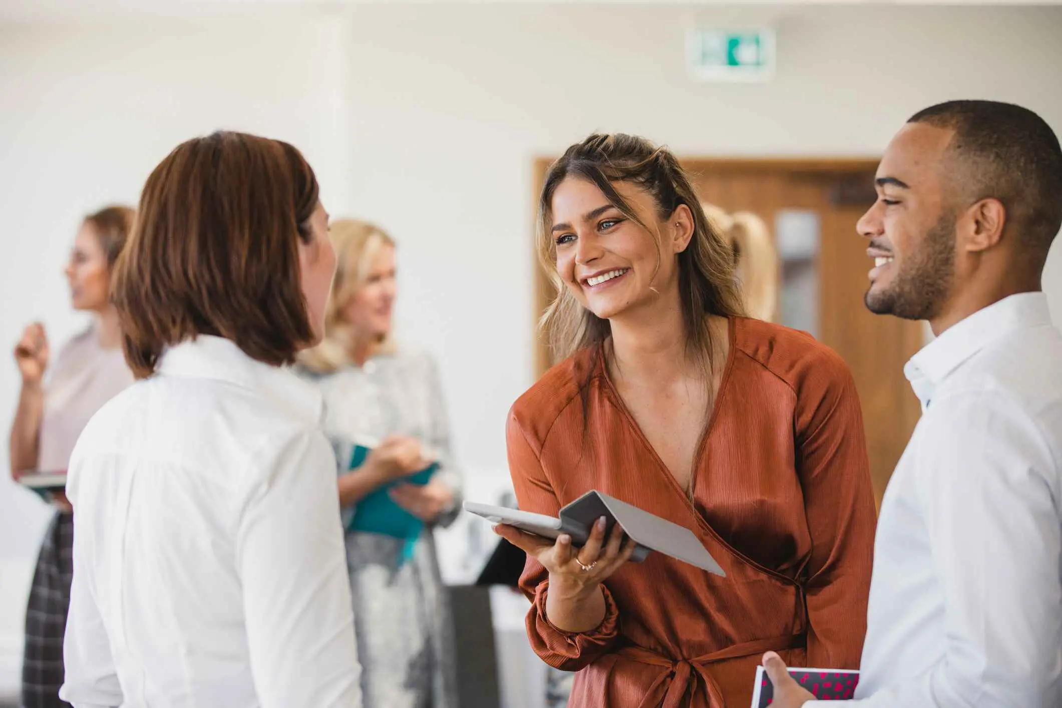 2 vrouwen en 3 mannen in zakelijke omgeving in gesprek