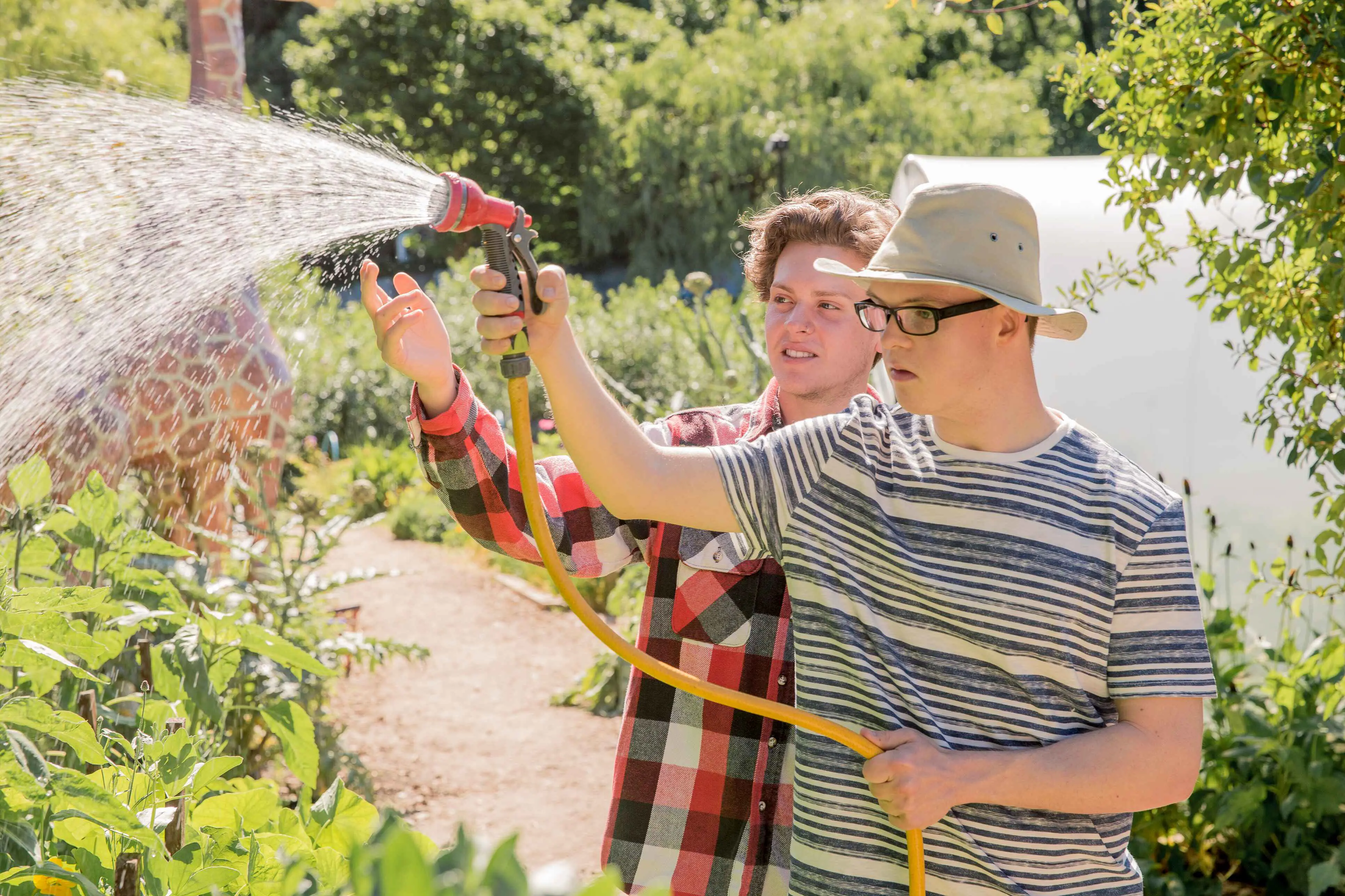 Jongen met beperking die planten water geeft