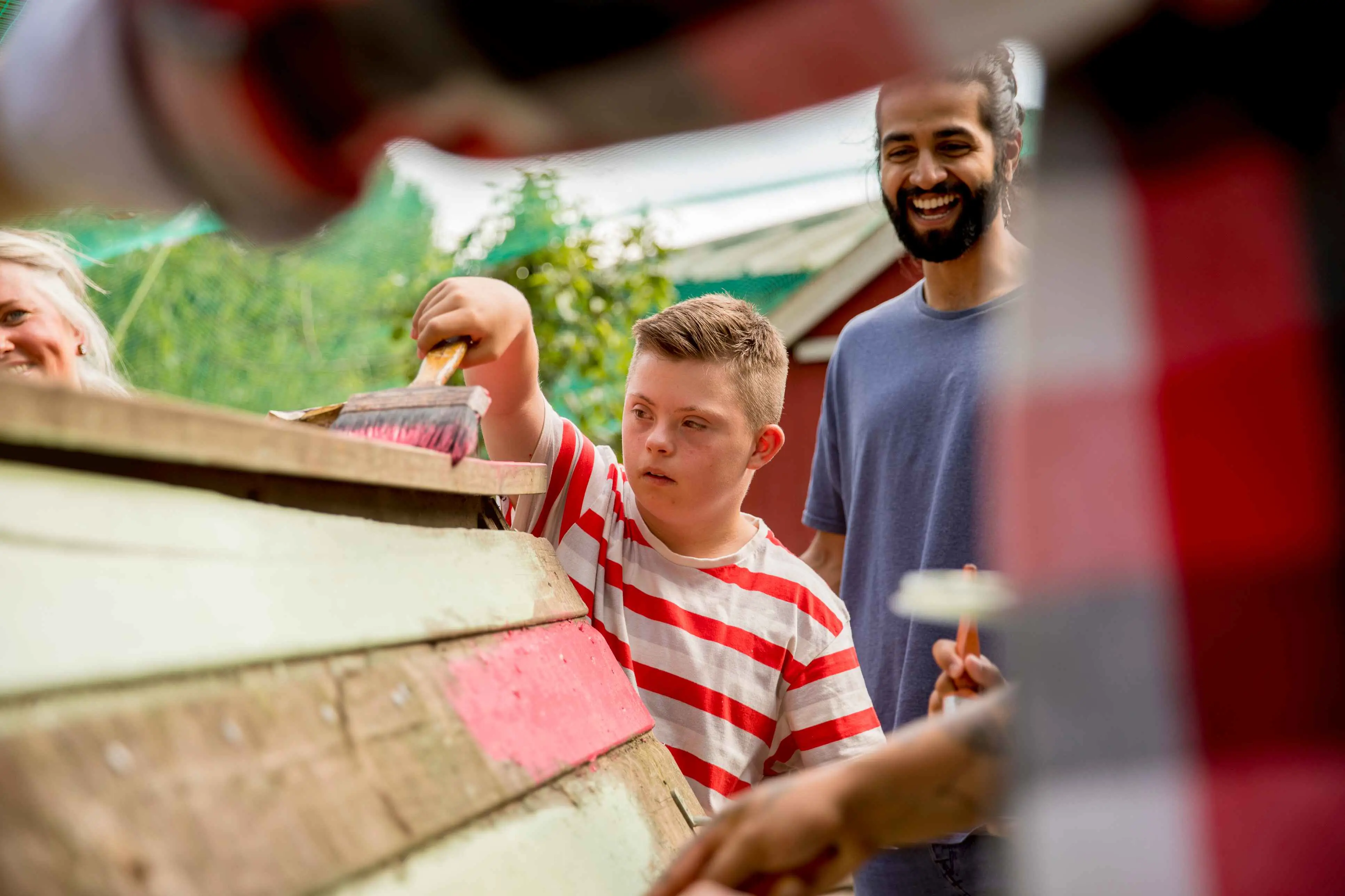 Jongen met down schildert huisje